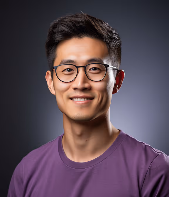 Smiling young Asian man wearing glasses and a purple shirt against a dark gradient background.